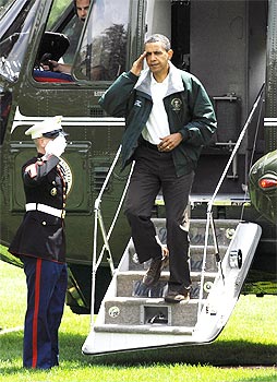 US President Barack Obama salutes as he arrives via the Marine One helicopter after a weekend visit to Camp David