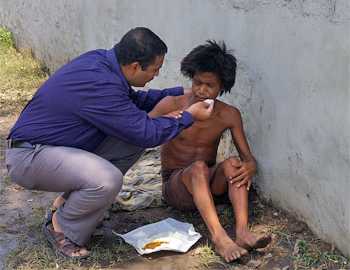 N Krishnan feeds a mentally ill person on a Madurai street