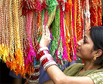 A woman looks at Rakhis at a market in Chandigarh