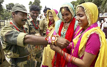 College students tie rakhi on the wrists of Indian Border Security Force (BSF) soldiers at the India-Pakistan check post at Wagah border