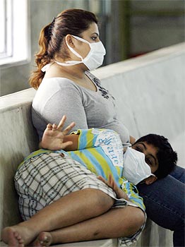 People wearing masks wait to get tested for H1N1 influenza at a special ward in Kasturba Hospital in Mumbai