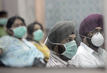 People wearing surgical masks wait for a H1N1 flu screening at Ram Manohar Lohia hospital in New Delhi