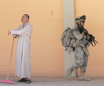 A US soldier walks past a resident during a patrol in Samarra, 100 km north of Baghdad