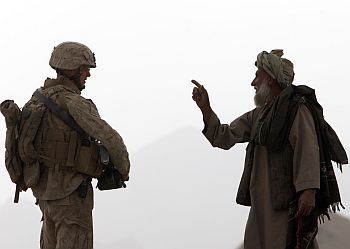 An Afghan man speaks with a US Marine during a patrol at a village in the Golestan district of Farah province