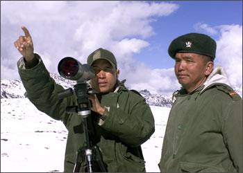 An Indian soldier points towards the border with China in Tawang