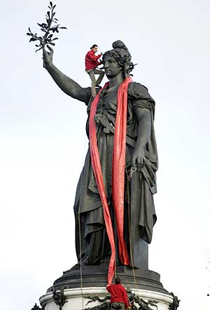 Members of French association 'AIDES' hang a red ribbon on the Republic statue in Paris