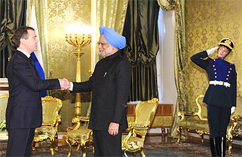 -Russia's President Dmitry Medvedev (L) shakes hands with India's Prime Minister Manmohan Singh (C) as they meet at the Kremlin