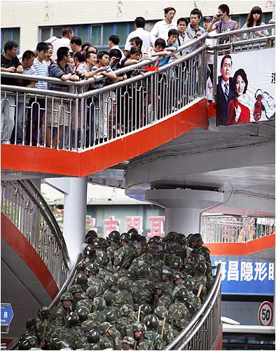 Chinese soldiers try to disperse a gathering of Han Chinese people in Urumqi
