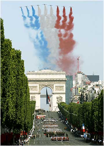 France's national colours trail over the Champs Elysees during the Bastille Day parade