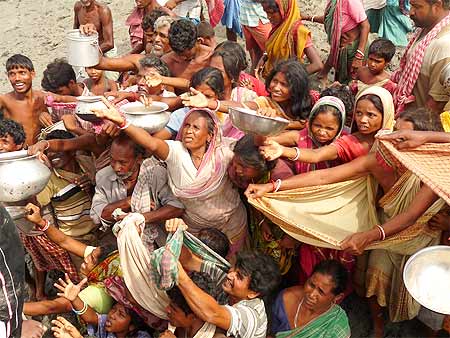 This file photo shows aila victims reaching out for food and water as a relief boat reaches Bijoynagar in Gosaba.