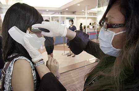 A staff member detects a woman arriving at a Singapore hospital