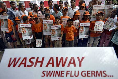 Children hold placards as they take part in a H1N1 flu awareness rally in Hyderabad