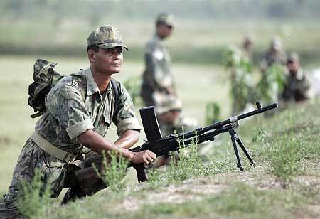 A paramilitary soldier mans his position before proceeding inside the villages of Lalgarh