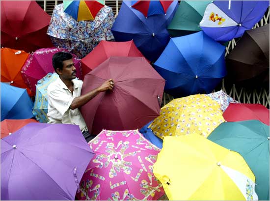 Aloke Saha, an Indian umbrella vendor, waits for customers in the eastern Indian city of Calcutta on June 14, 2004. Monsoon rains are sweeping across many parts of India after a long spell of intense heat.