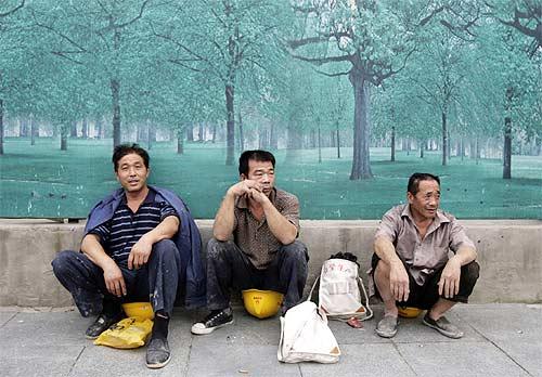 Chinese workers chat at a pavement in Beijing. Ordinary Chinese, polls say, consider India as their biggest enemy.