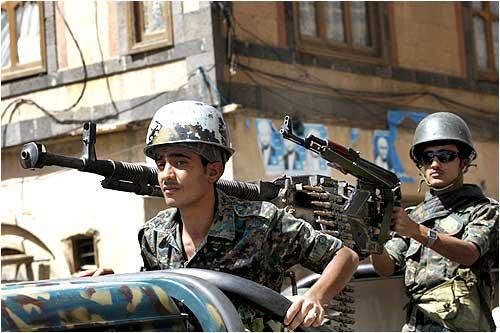 Police personnel stand guard on a police vehicle outside a state security court during the trial of 16 Al-Qaeda men