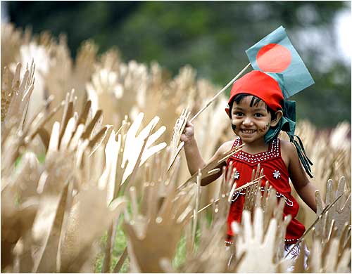 A child plays with the Bangladesh national flag