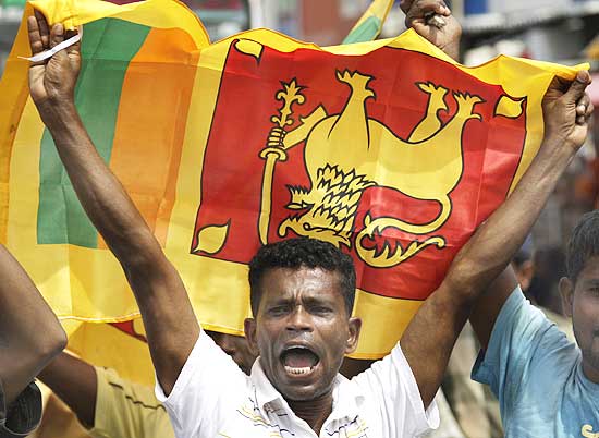 A Sri Lankan man waves his national flag as he celebrates the defeat of the Tamil Tigers
