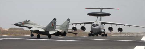 A MiG-29 lands after escorting the first IAF AWACS (background) at the Jamnagar air base
