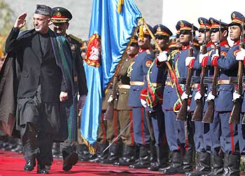 Afghanistan President Hamid Karzai inspects the guard of honour upon his arrival at the presidential palace in Kabul