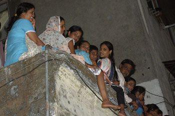 Local residents watch the ceremony from a rooftop