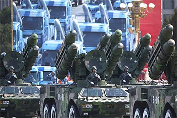 Soldiers stand in People's Liberation Army rocket launcher trucks they rumble past Tiananmen Square