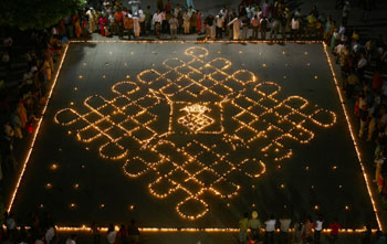Onlookers stand beside earthen lamps during Diwali celebrations in Chandigarh