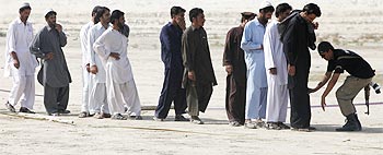 Men fleeing the offensive in South Waziristan being checked by police.