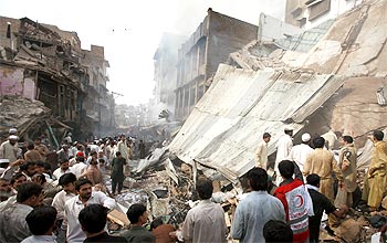Residents, rescue workers and security officials at the blast site in Peshawar