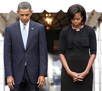 US President Barack Obama and first lady Michelle Obama observe a moment of silence at the White House