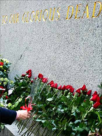 A woman places flowers on the cenotaph at Martin Place in central Sydney