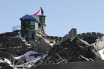 Chinese soldiers put up a flag atop their post at the India-China trade route at Nathu-La Pass