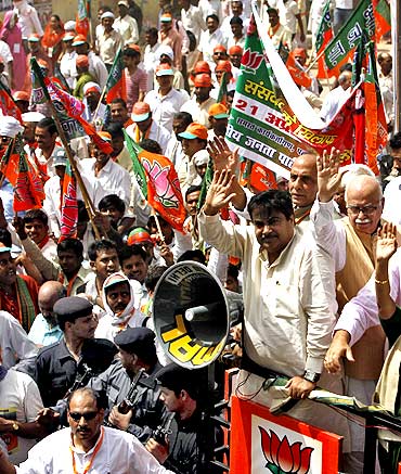 Bharatiya Janata Party President Nitin Gadkari and BJP leaders L K Advani and Rajnath Singh greet supporters in New Delhi