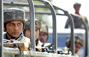 Soldiers patrol a curfew-bound locality during a flag march in Panthachowk on the outskirts of Srinagar on July 8