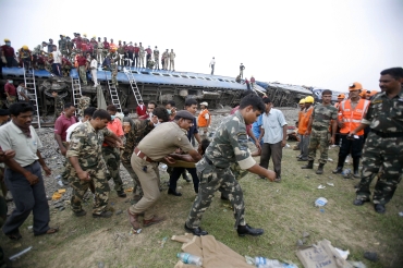 Soldiers carry the body of an injured victim at the site of a train mishap caused by Maoists in Bengal