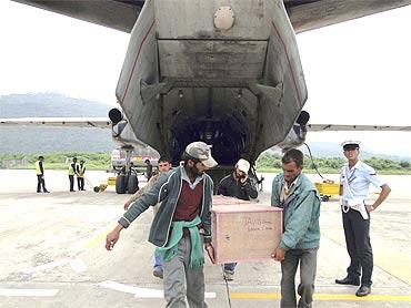 Men carry the body of a victim who was killed in flash floods in Leh