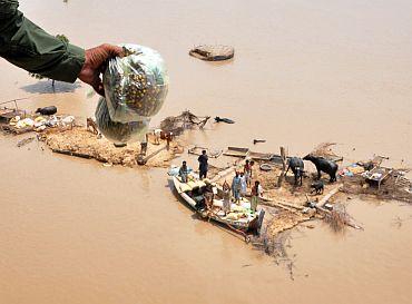 Families marooned by flood waters recieve food from an Army helicopter in the Rajanpur district of Pakistan's Punjab province