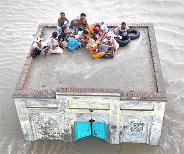 A family takes refuge on top of a mosque while awaiting rescue in Pakistan's Punjab