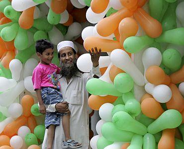 A man shows balloons in the colours of the Indian flag to his child at a market on August 15.