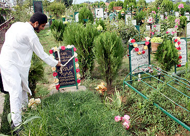 A youngster pays respect at Tufail's grave in the martyrs' graveyard, downtown Srinagar