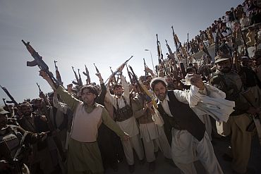 Members of the local Lashka hold their weapons while dancing in a show-of-force in Bajaur Agency