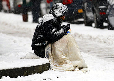 A beggar sits in the snow in Edinburgh