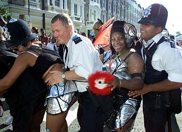 Police officers dance with revellers at the Notting Hill carnival
