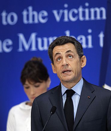 Sarkozy (R) delivers a speech as his wife Carla Bruni-Sarkozy stands by during a ceremony in tribute to the victims of the Mumbai terror attacks