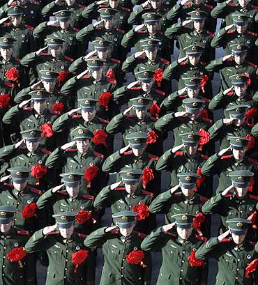 Paramilitary policemen salute during a ceremony at an army base in Taiyuan, Shaxi province