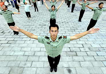 Staff members of the PLA take part in a gymnastic exercise session in Taimiao, Beijing