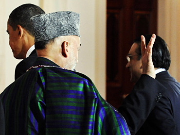 Afghanistan President Hamid Karzai (C) waves as he and Pakistan's President Asif Ali Zardari (R) depart with US President Barack Obama (L) after addrerssing a joint conference at the White House