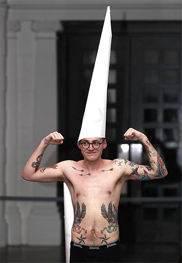 A demonstrator flexes his muscles during a protest at the Tate Britain gallery in central London