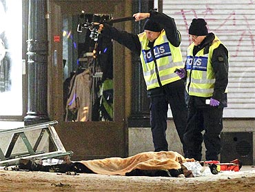Forensic experts examine the remains of a suspected suicide bomber in central Stockholm