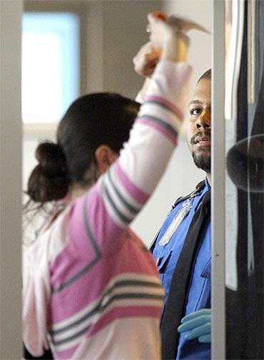 A traveller undergoes a millimeter wave scan before boarding her flight at Ronald Reagan Washington National Airport in Washington